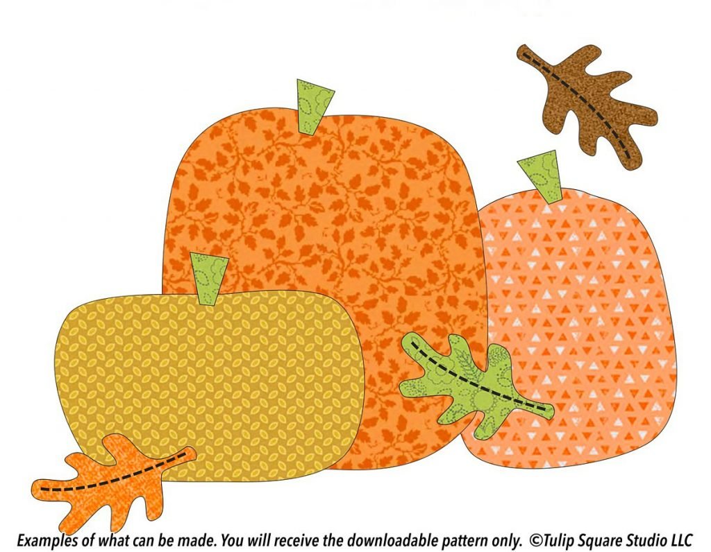 Three chunky pumpkins made of whimsical patterned fabric, with autumn leaves falling around them.