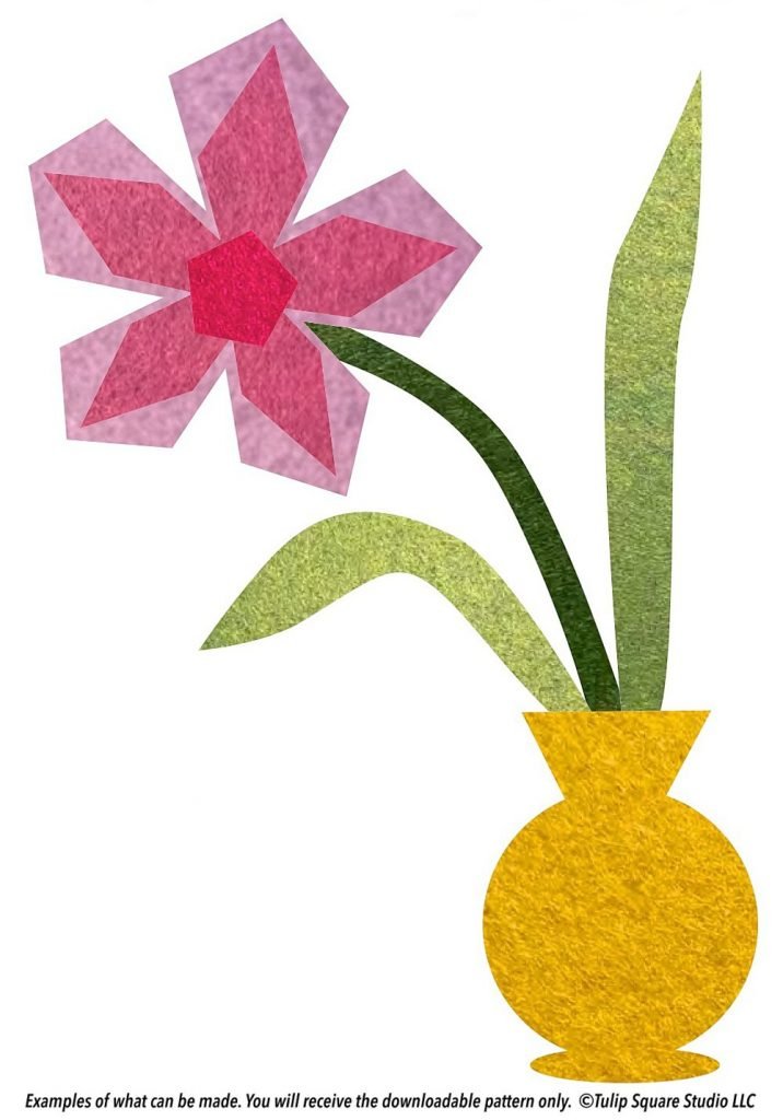 Stylized flower in shades of pink, in a yellow vase. All created with layers of felt appliqué.