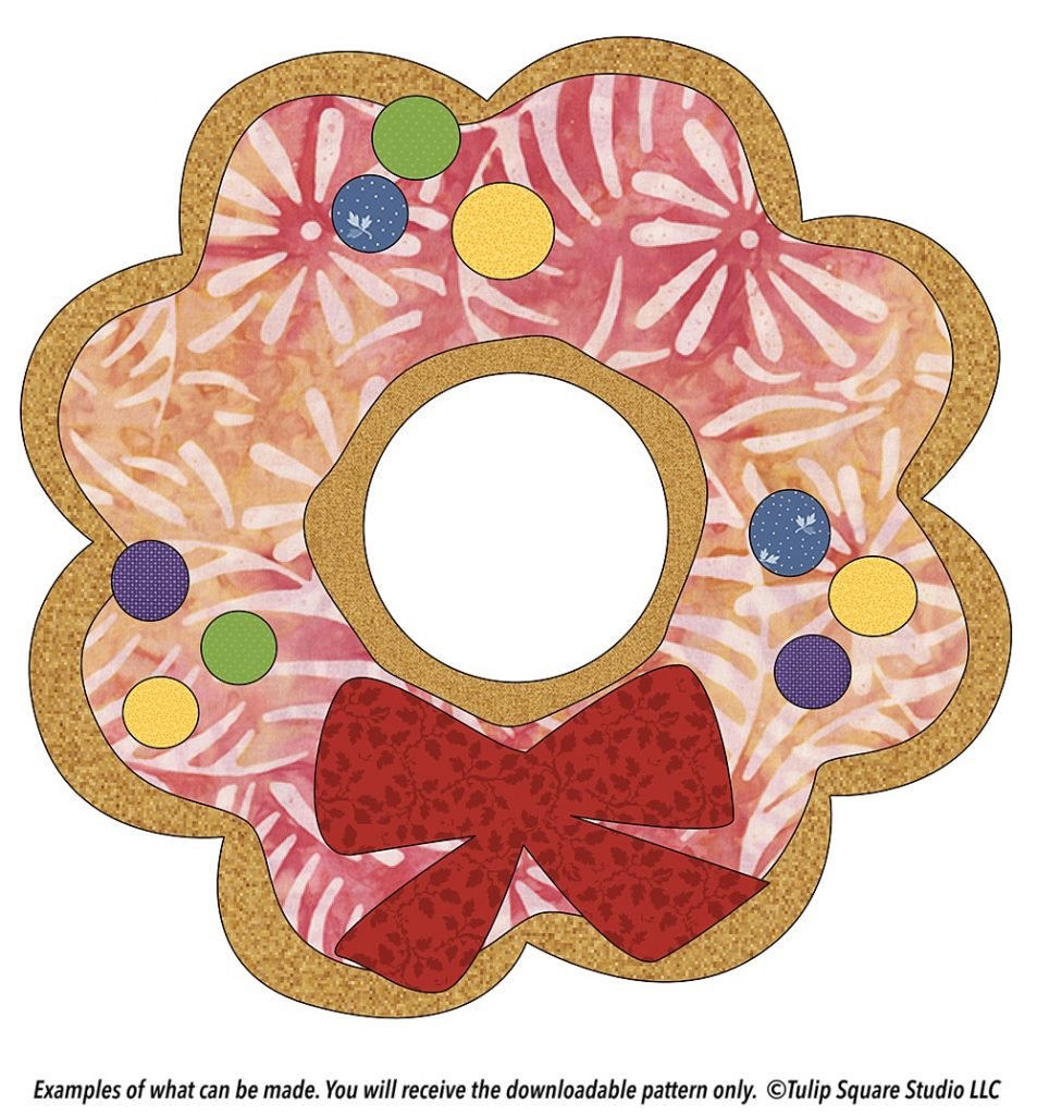 Fabric appliqué design of a scalloped cookie shape, decorated as a Christmas wreath.
